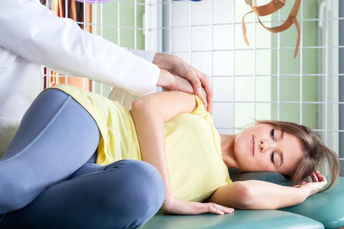 Professional physiotherapist massaging female patient's arm, horizontal